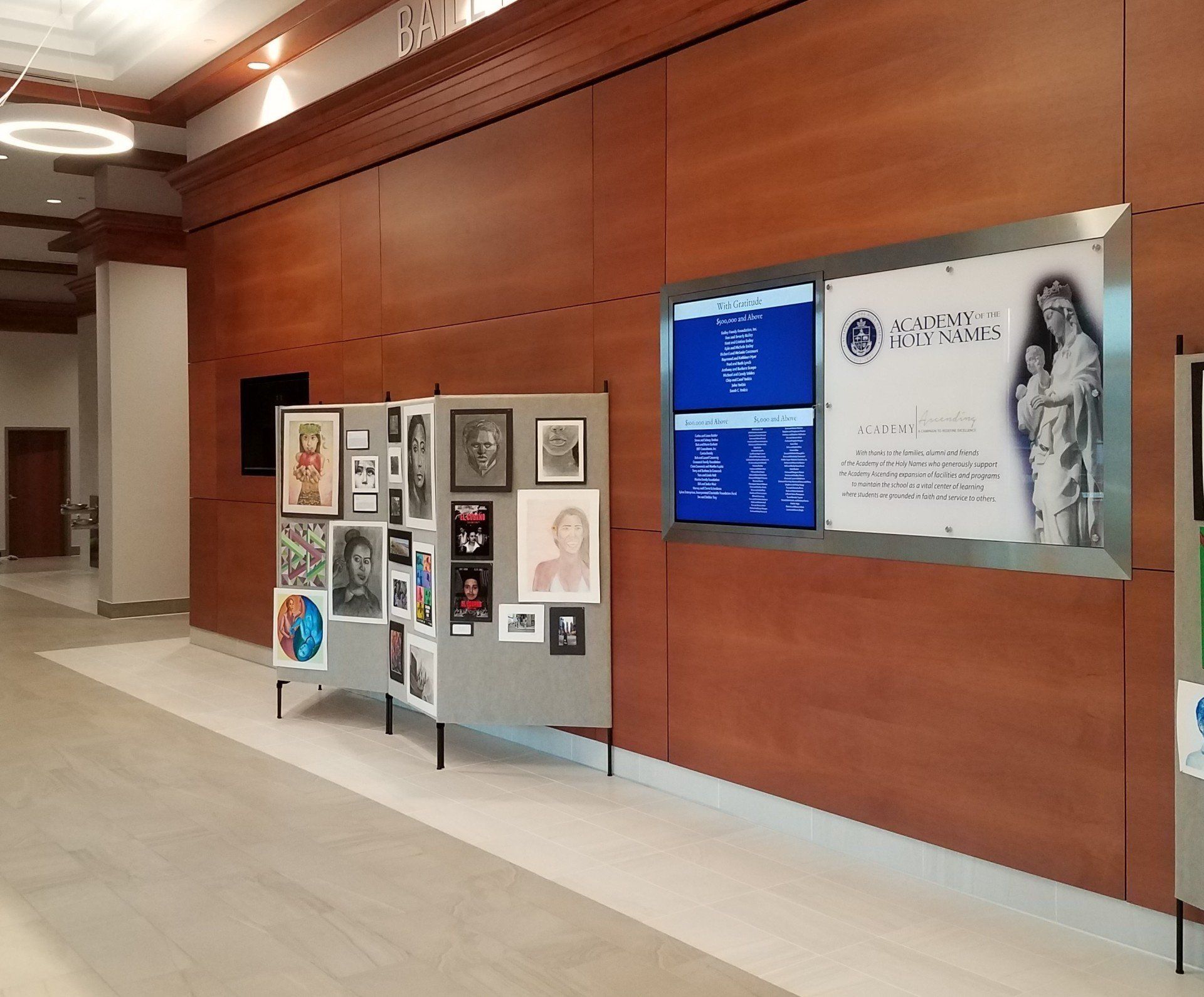 A hallway with a display of artwork on a wall