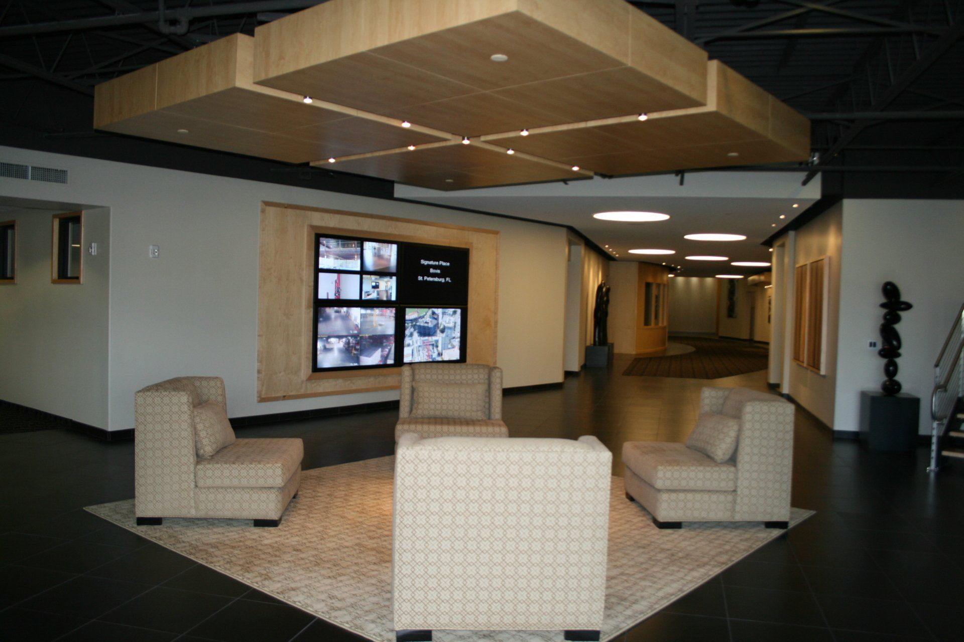 A living room with chairs and a tv on the wall