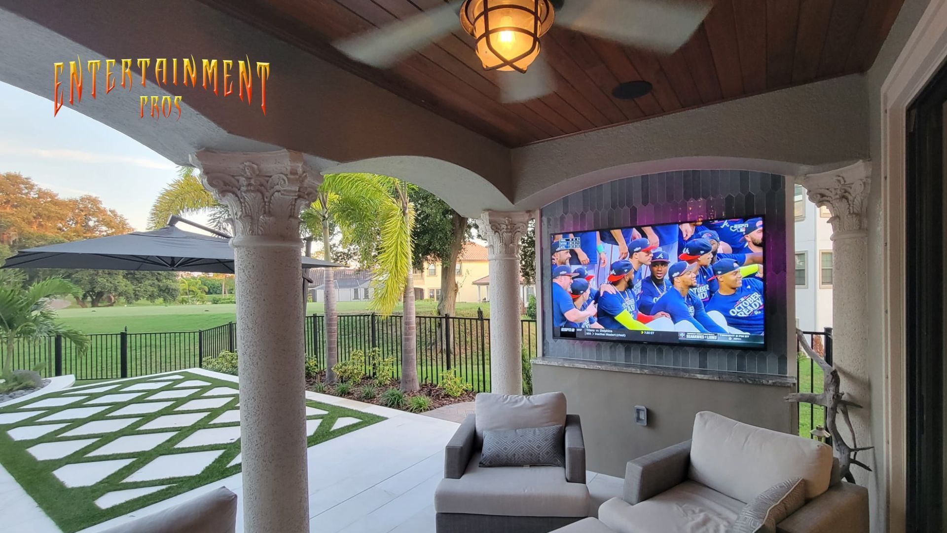 A patio with a television and a ceiling fan