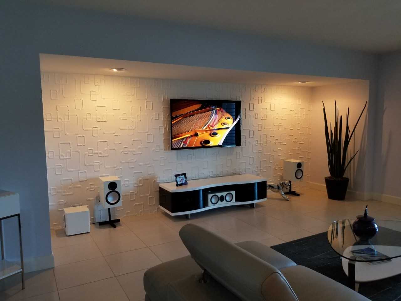 A living room with a flat screen tv on the wall.