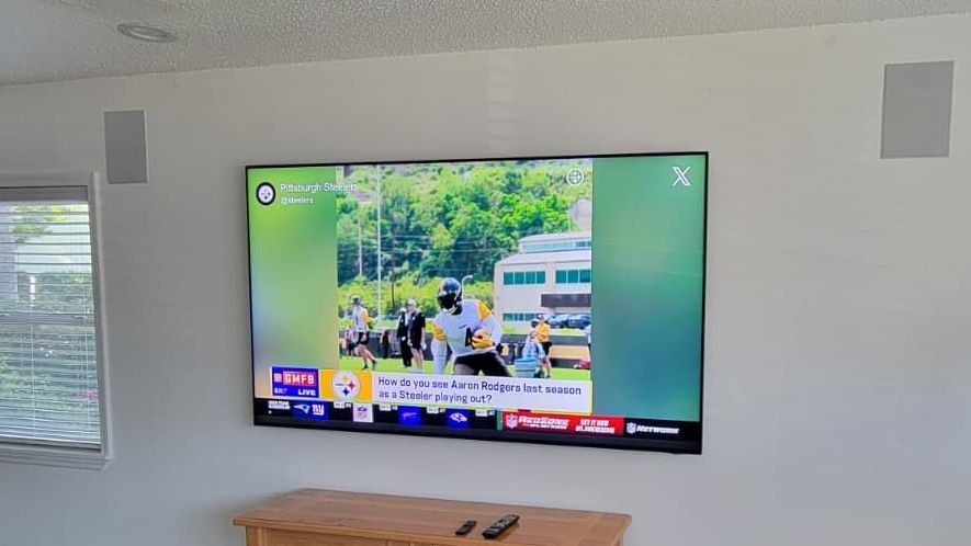 A flat screen tv is hanging on a wall in a living room.