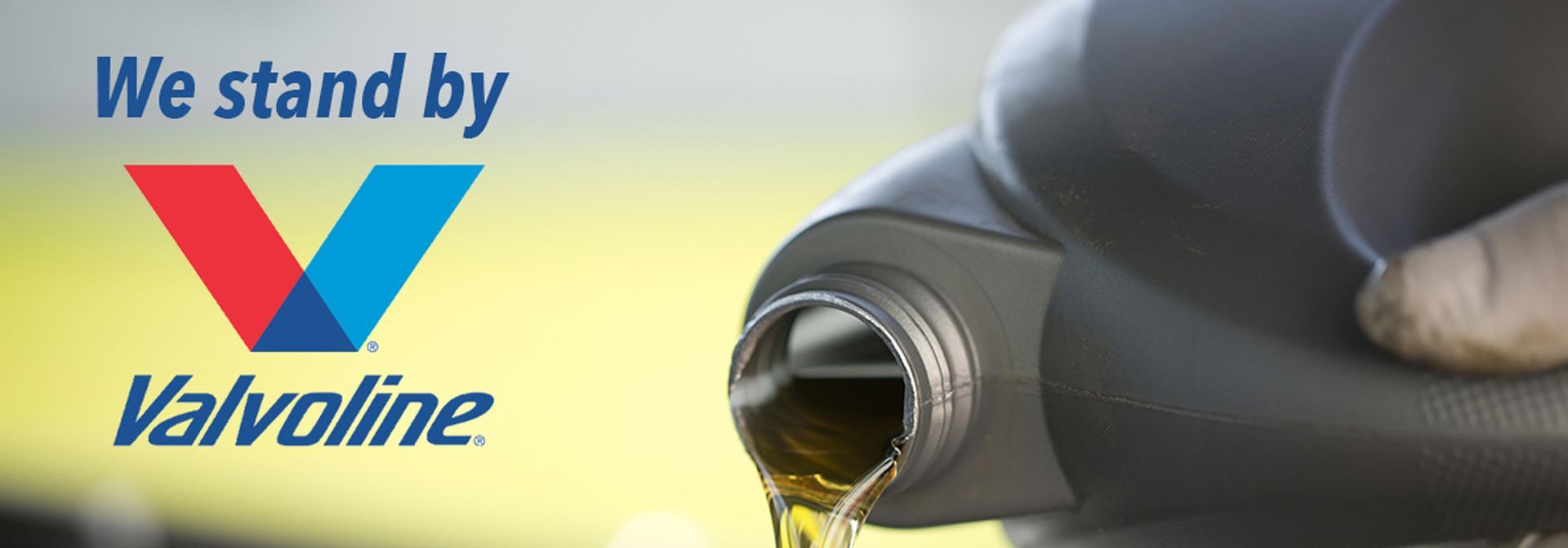 A bottle of valvoline oil is being poured into a car