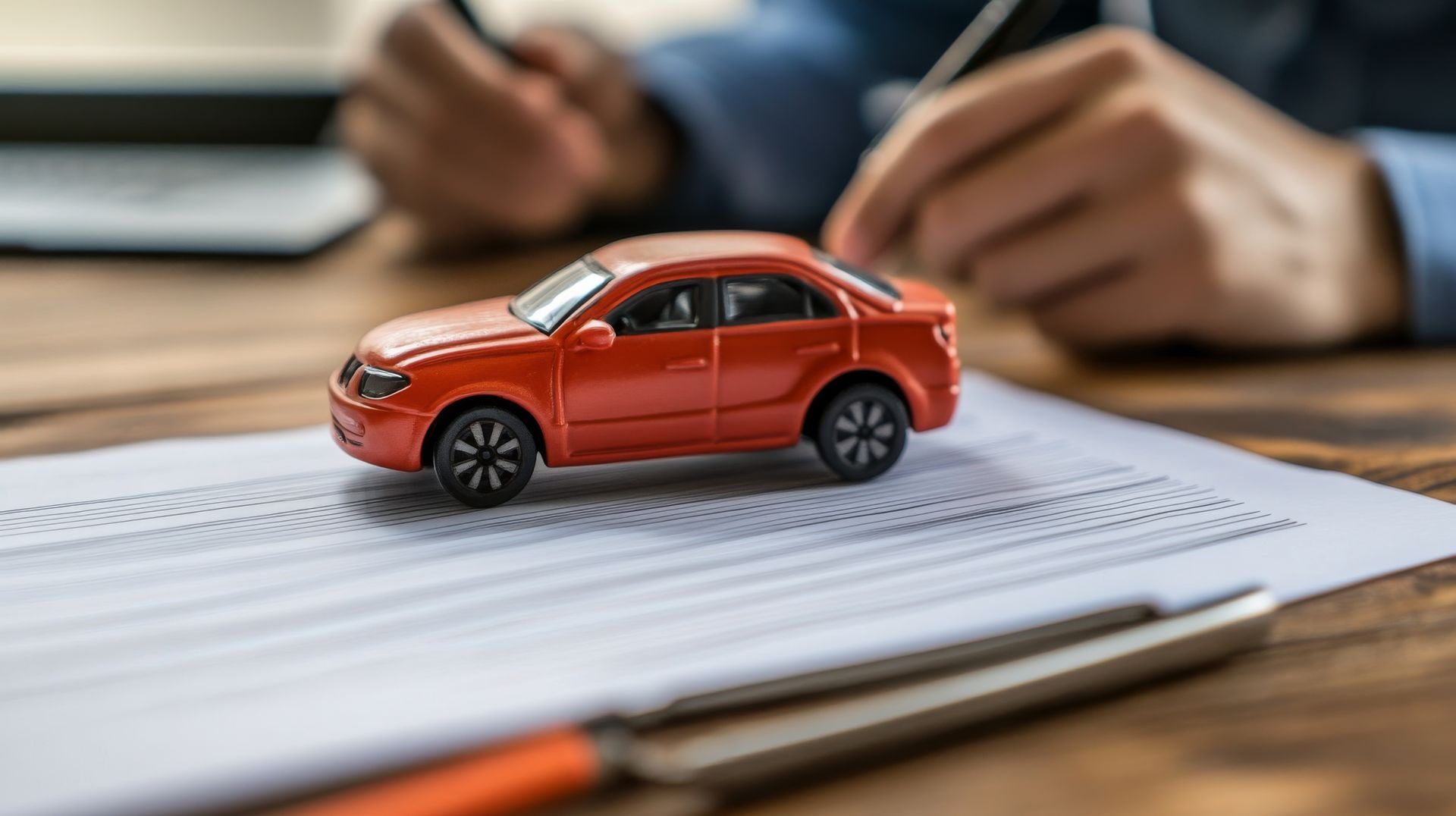 Small red toy car on legal papers; find a DUI attorney for accident compensation help.