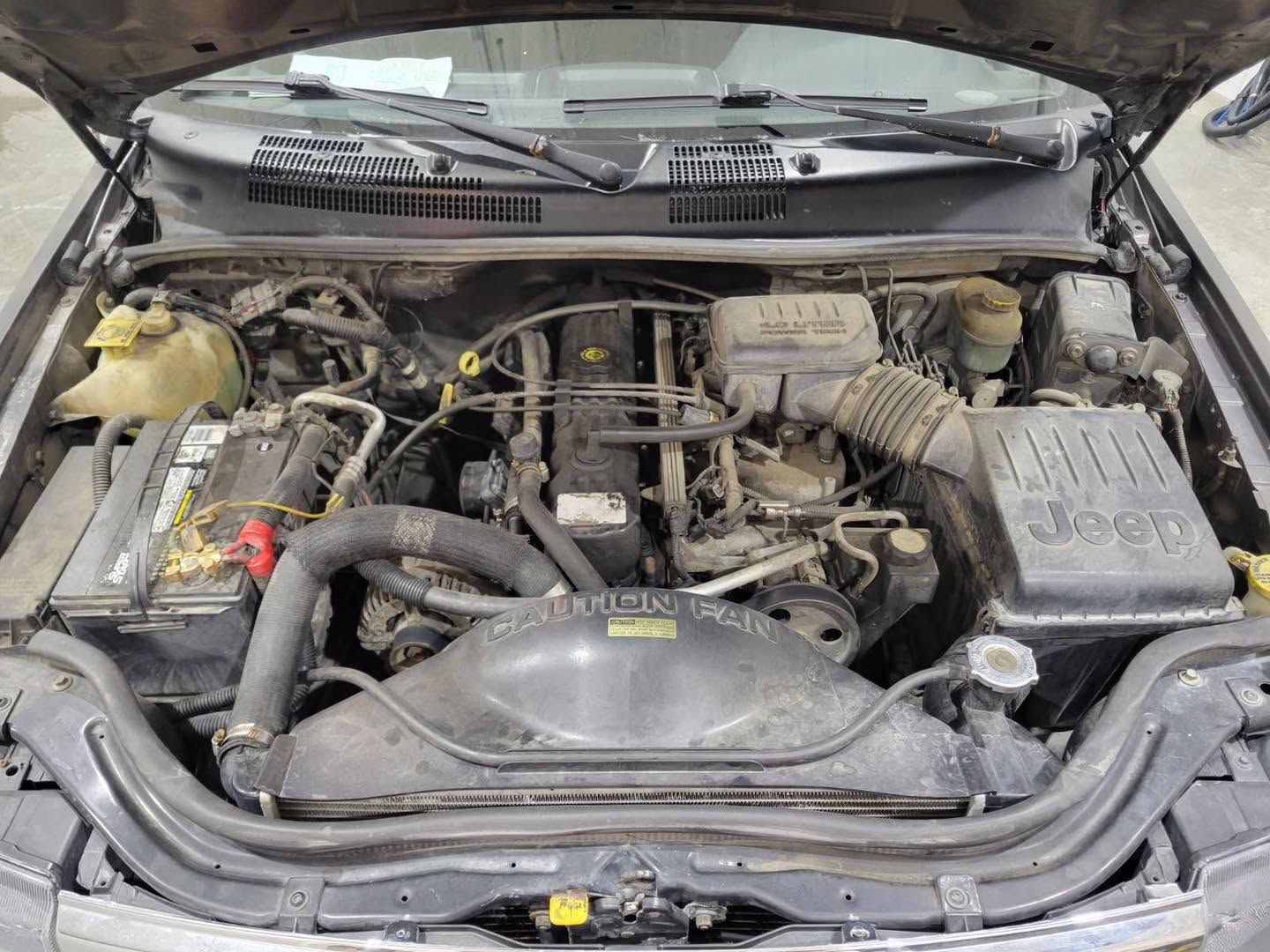 The engine of a jeep grand cherokee is shown with the hood open.