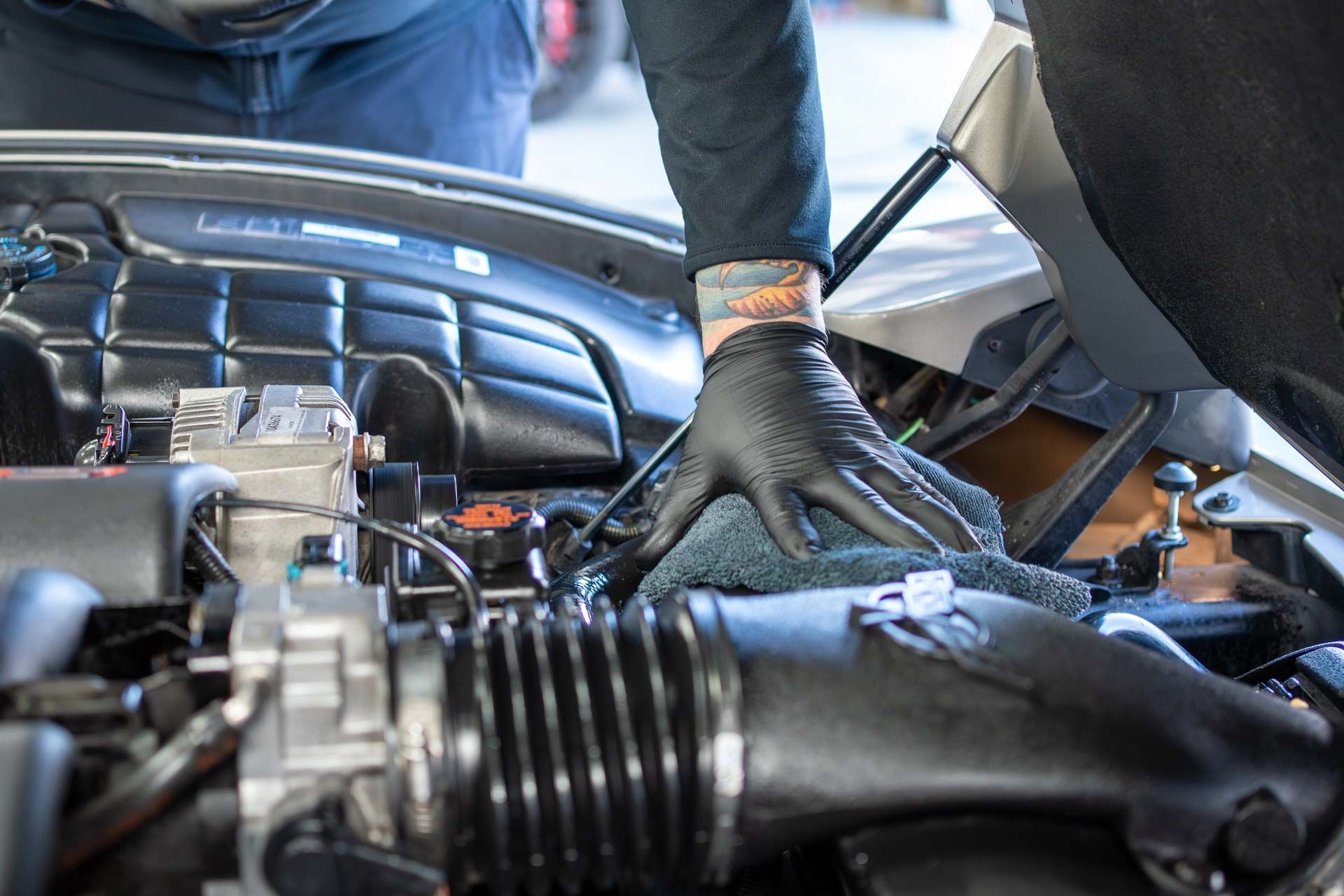 A man is working on the engine of a car.