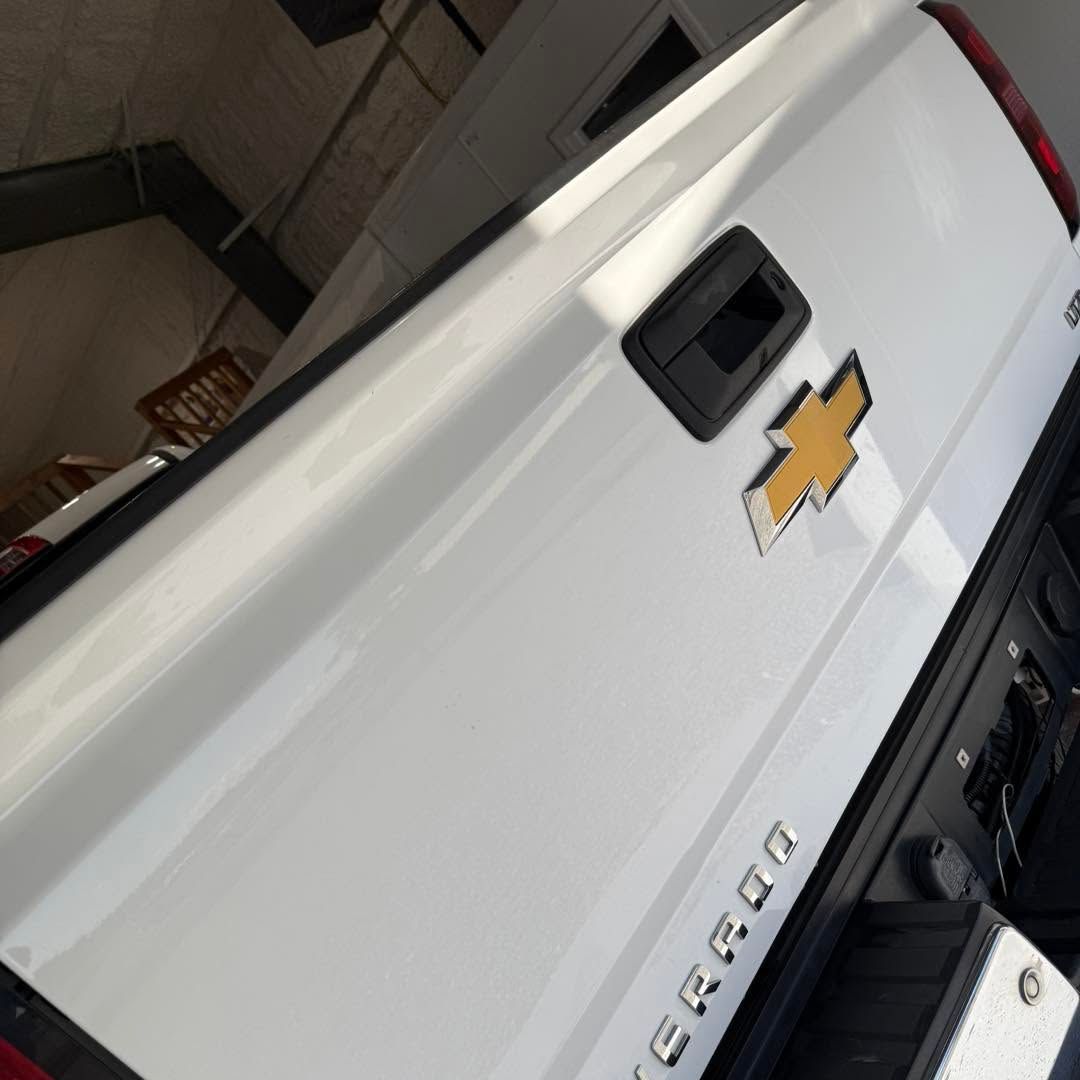 A white chevrolet cargo truck is parked in a garage