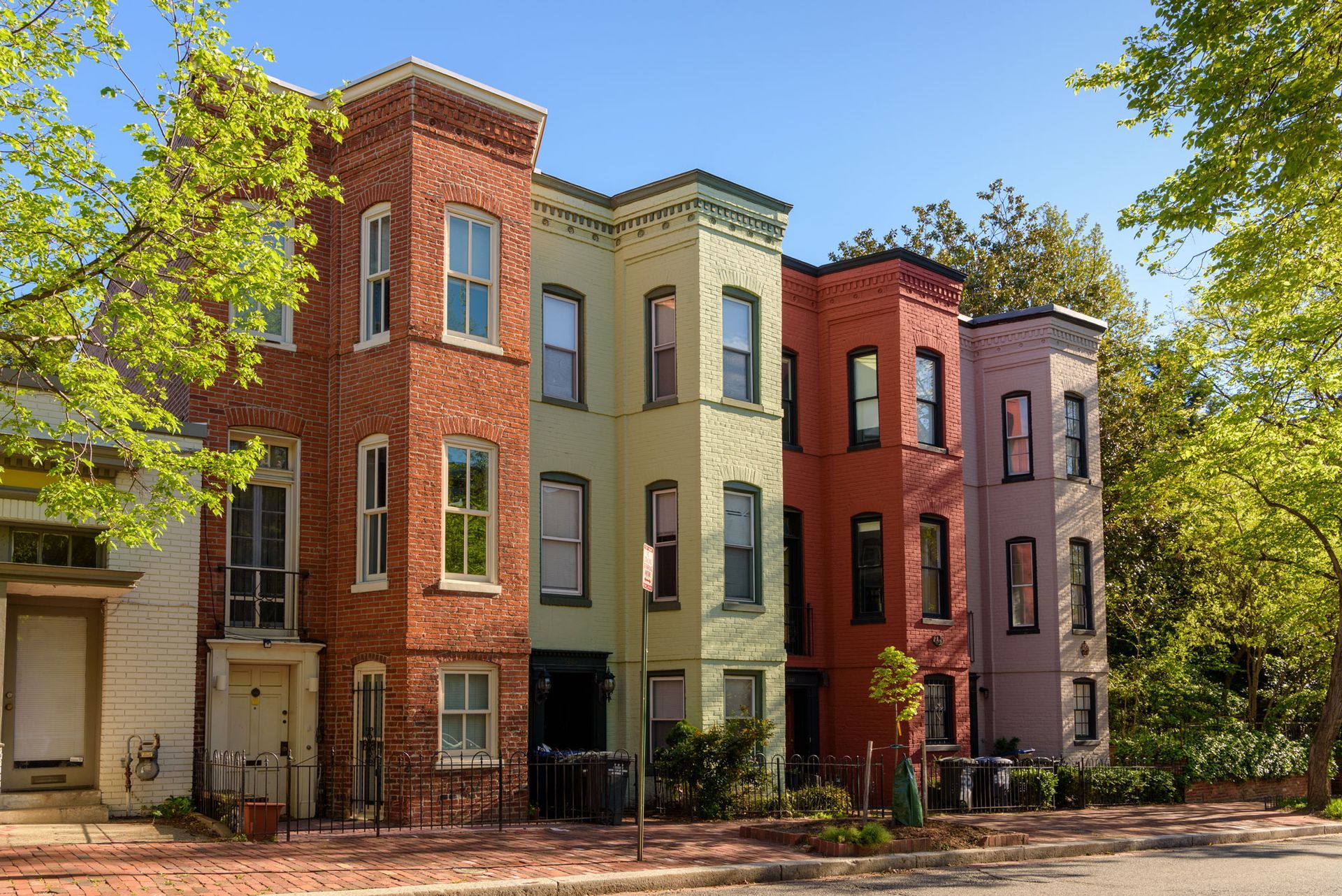 A row of brick buildings are lined up next to each other on a sunny day.