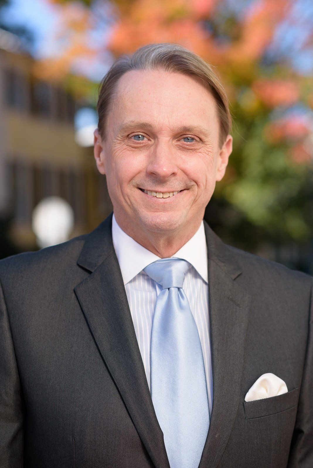 A man in a suit and tie is smiling for the camera.