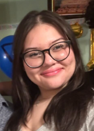 A woman wearing glasses is smiling for the camera