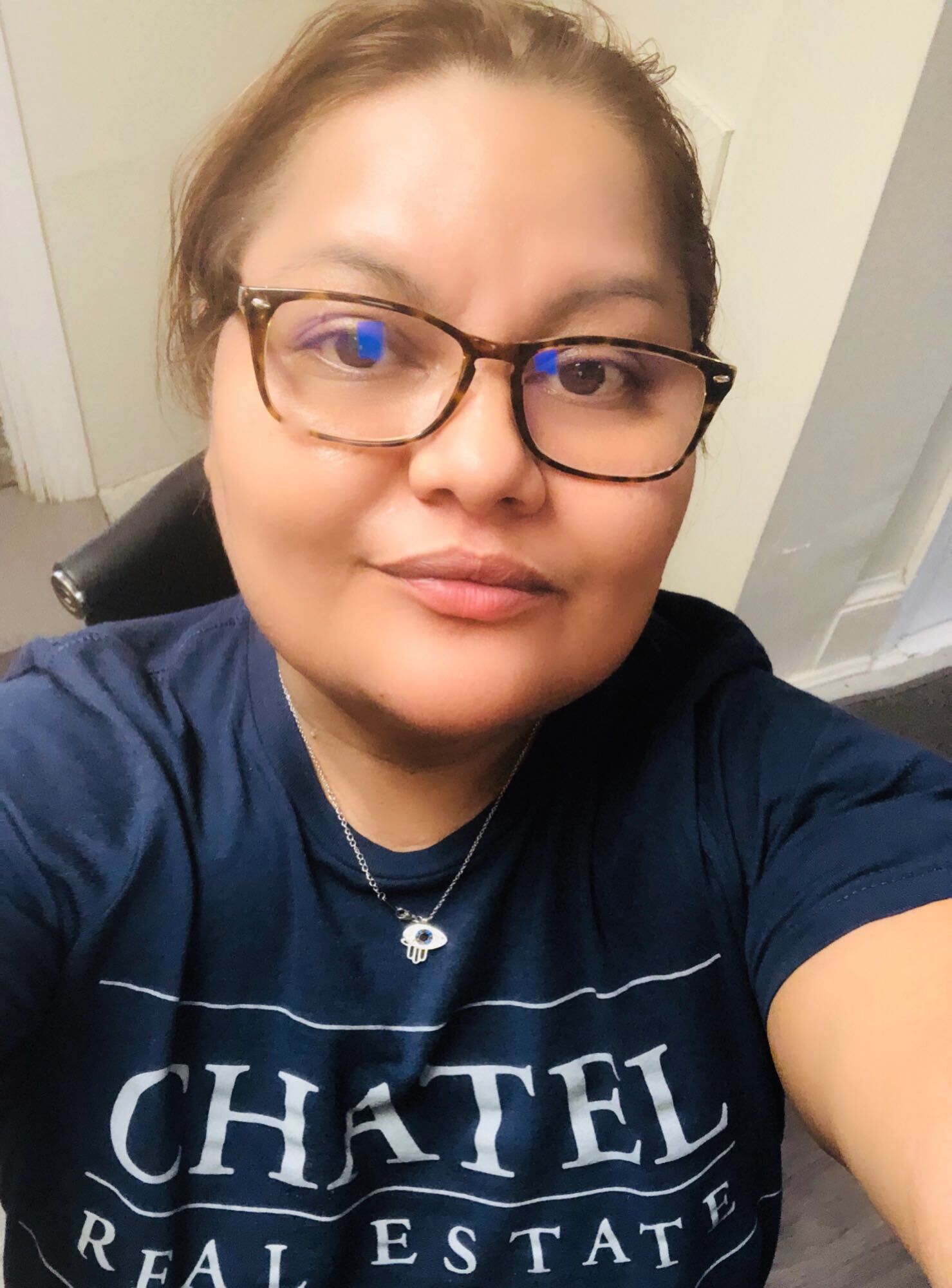 A woman wearing glasses and a chatel real estate shirt