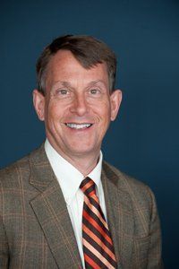 A man in a suit and tie is smiling for the camera.