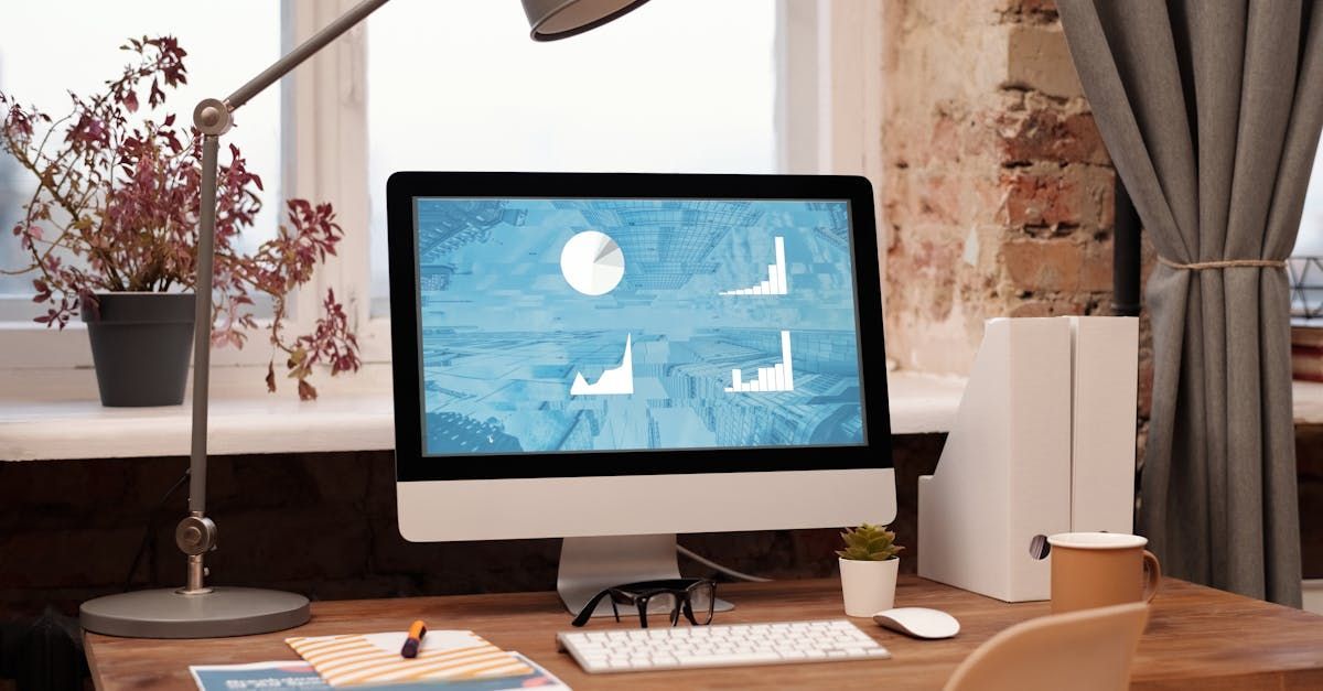 A computer is sitting on a wooden desk in front of a window.