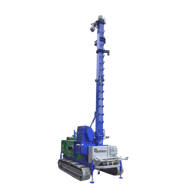 Piattaforma di perforazione blu e verde su cingoli con albero alto, utilizzata per perforazioni geotecniche.