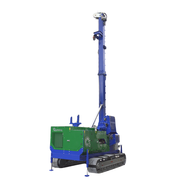 Piattaforma di perforazione blu e verde con un alto albero su cingoli, probabilmente destinata alla costruzione.