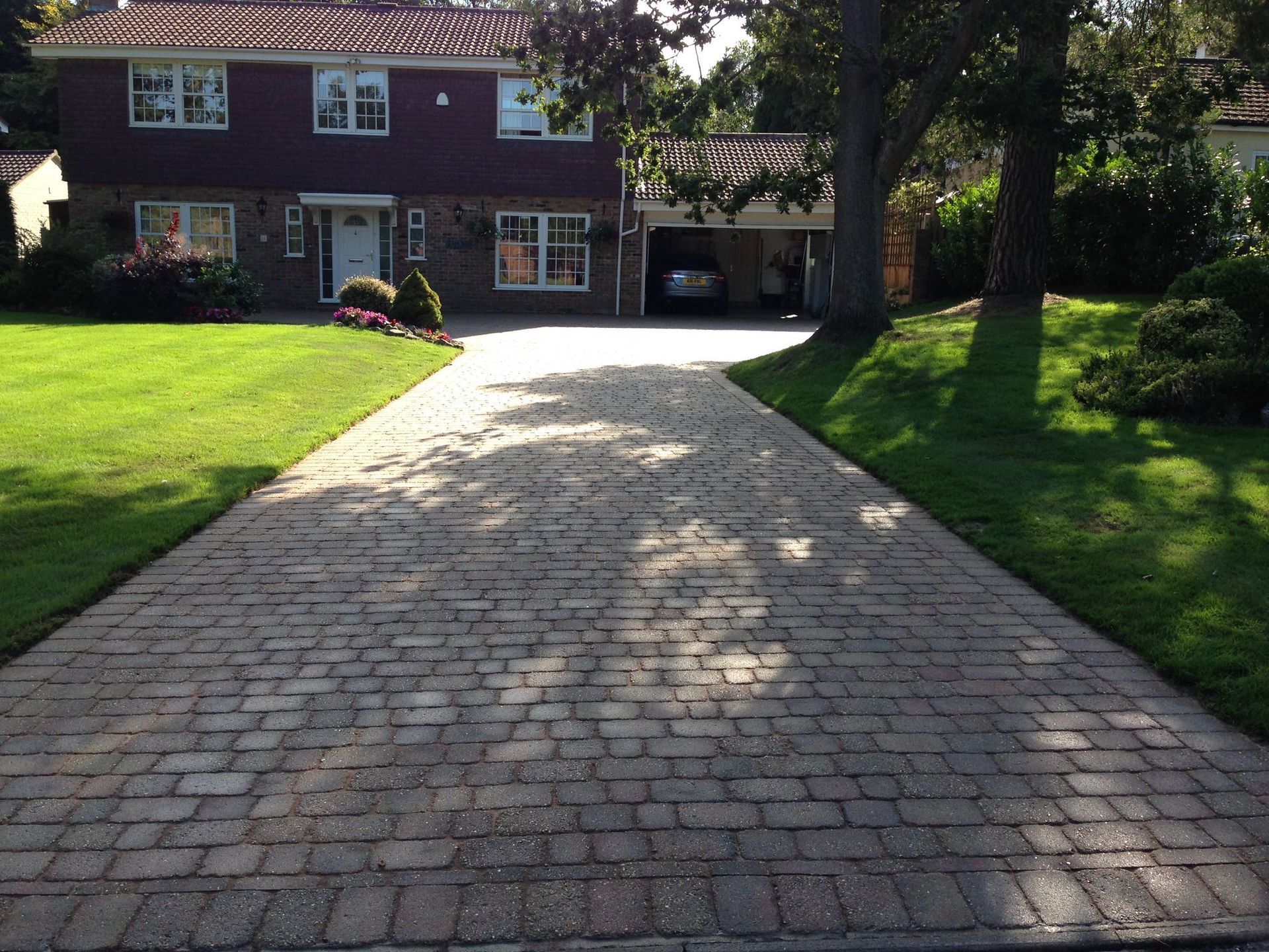 Block paved driveway with shadow of the trees to the right