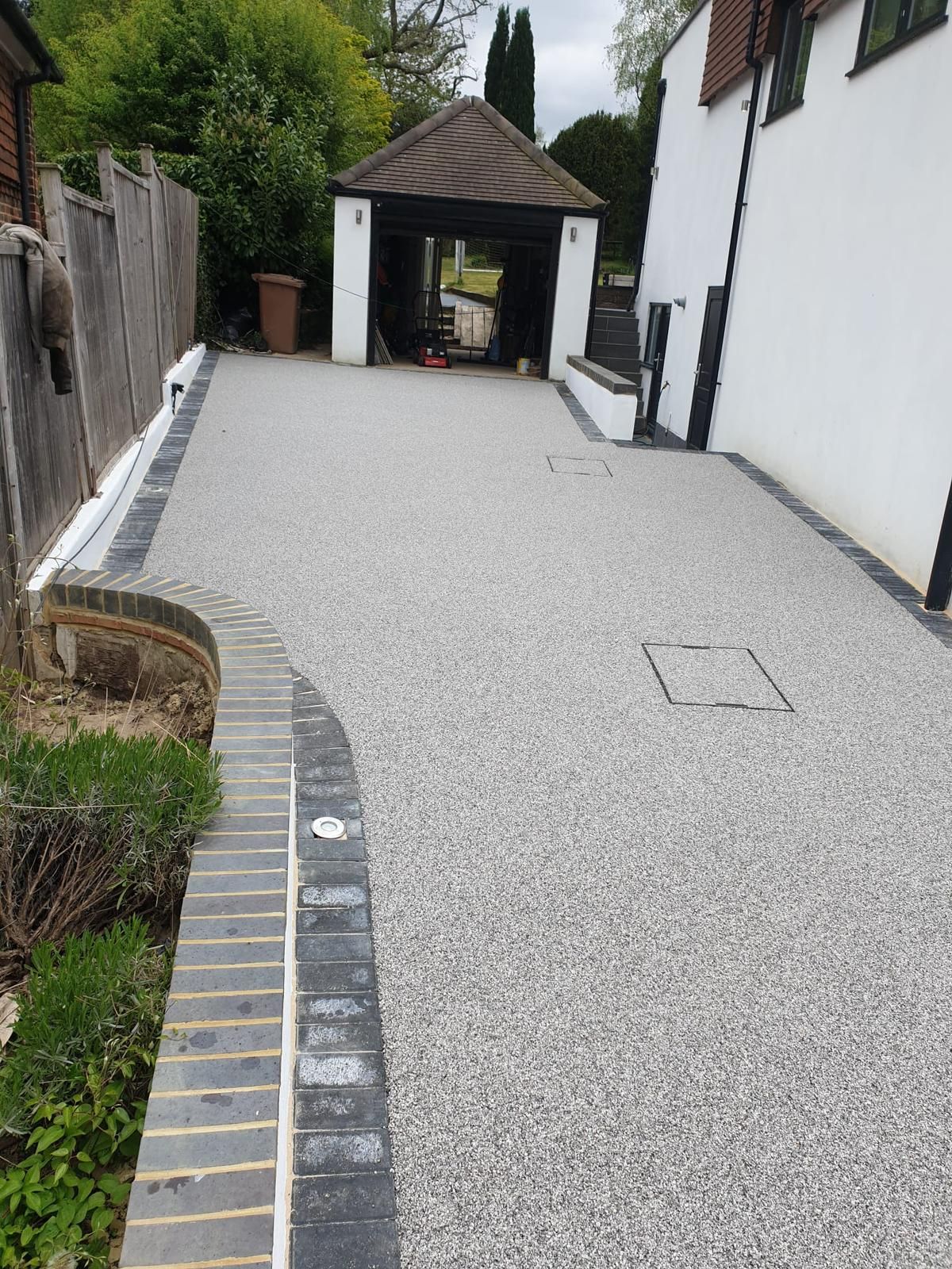 A gravel driveway leading to a house with a gazebo in the background.