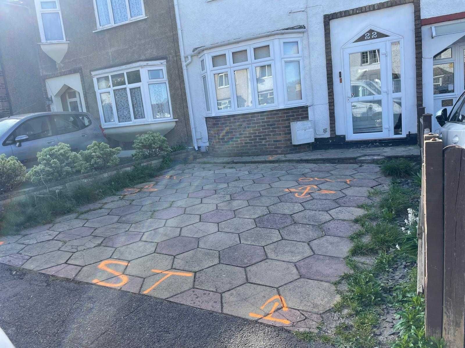 Row of houses with cars parked in front on a sunny day.