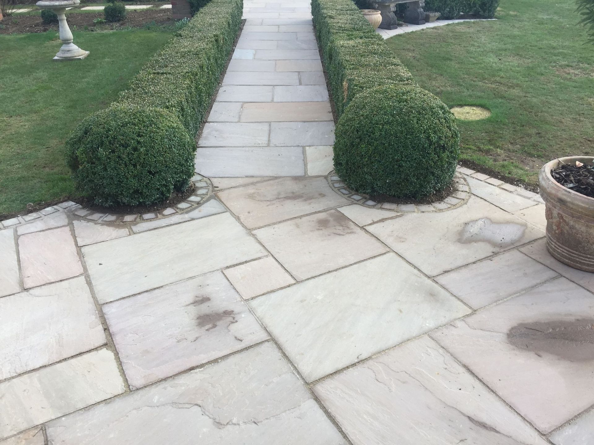A patio with a walkway leading to a garden