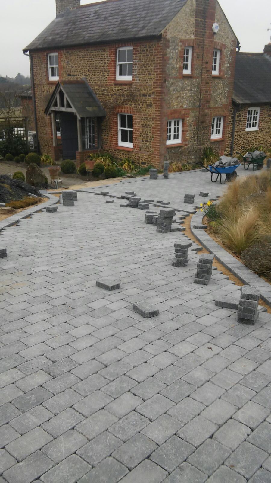 A large brick house with a brick driveway in front of it.