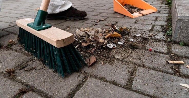 A person is sweeping the driveway