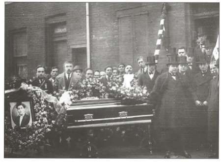 A group of men are standing around a coffin in a black and white photo.