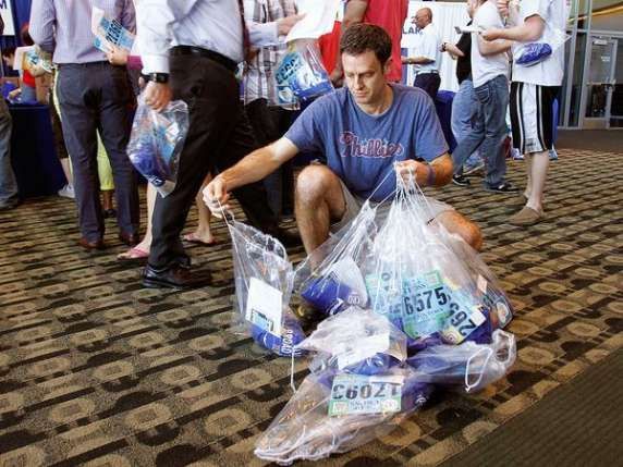 A man is kneeling down holding a bag that says c6027