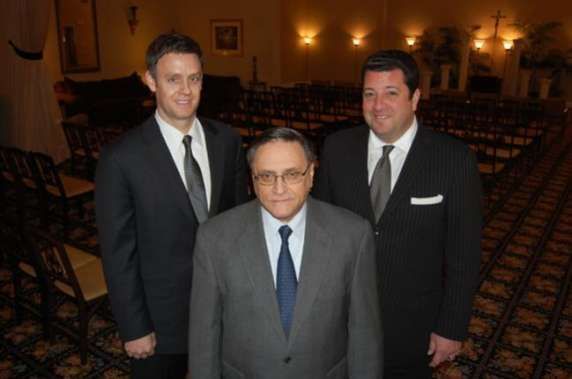 Three men in suits and ties are posing for a picture