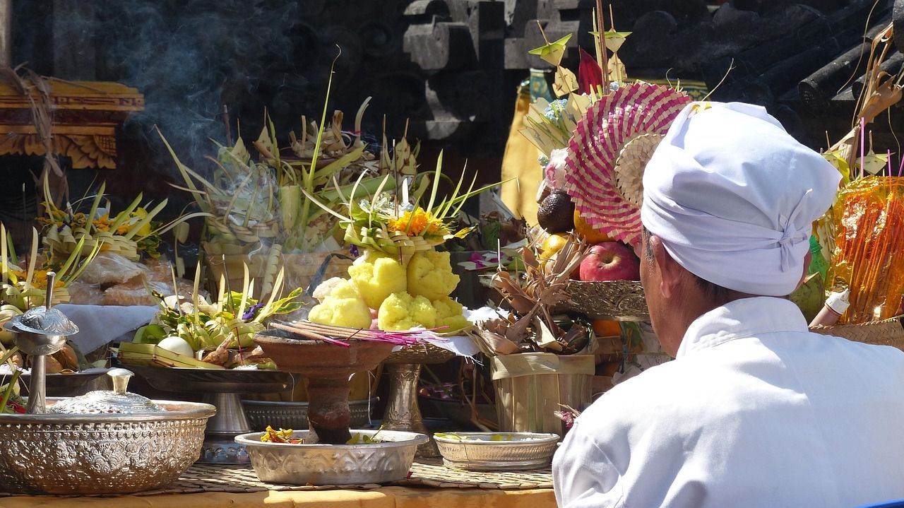APerson sitting in front of Buddhist fruit offerings