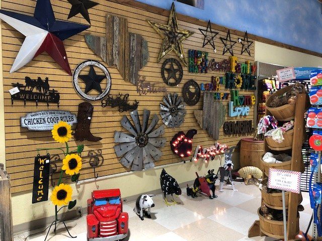 Texas-themed decor display with metal art, including stars, a state outline, and animals, in a store setting.