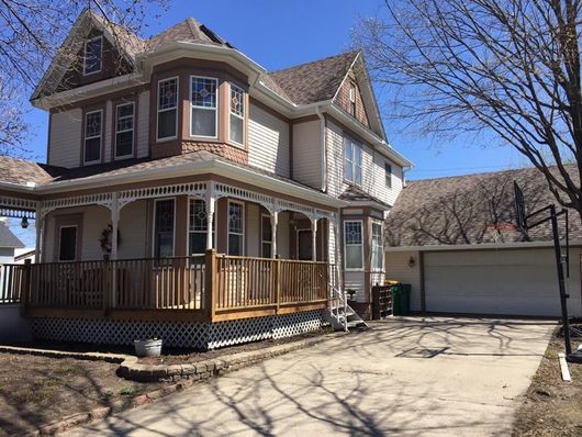 A large house with a large porch and a garage.
