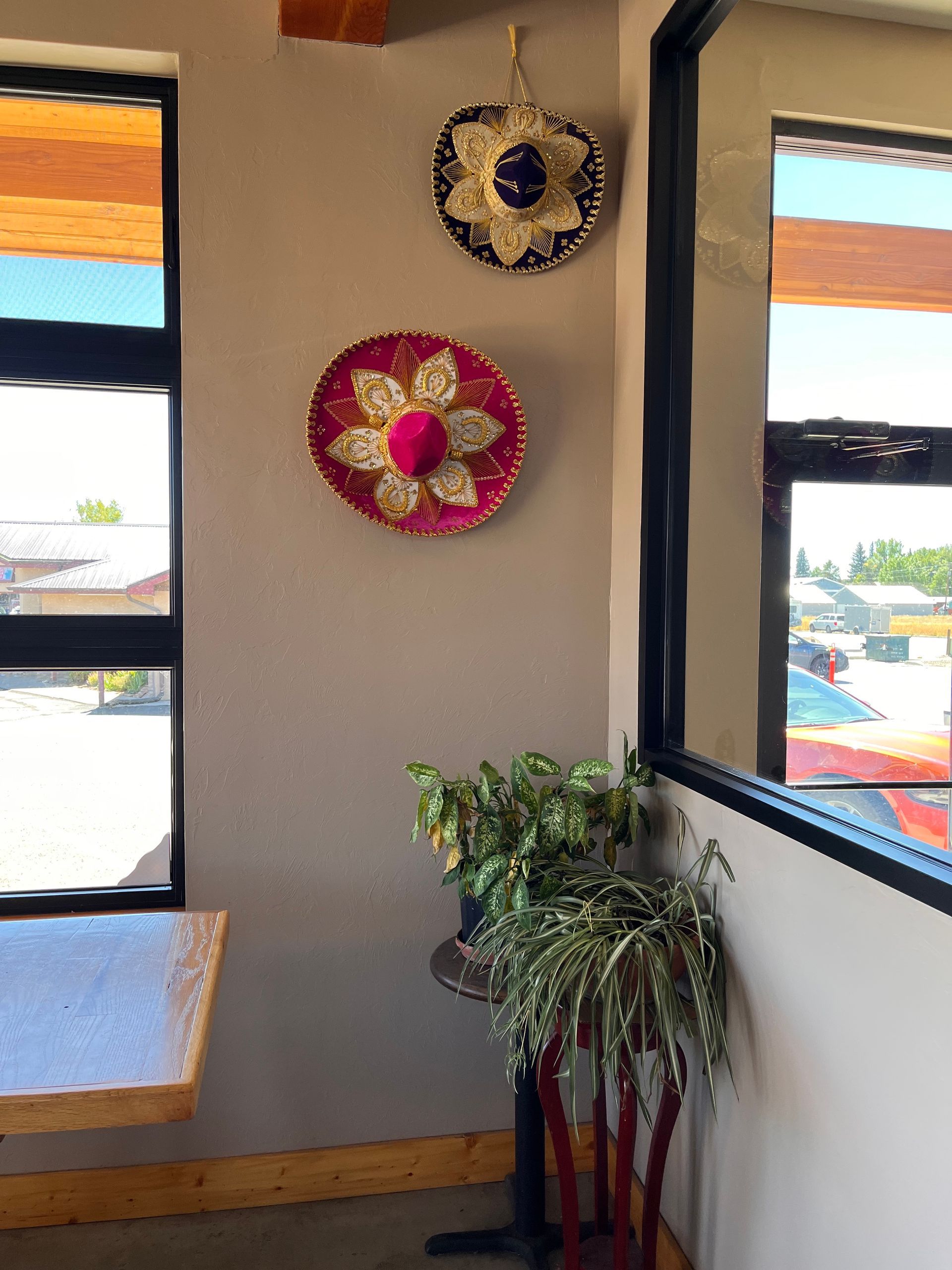 Two sombrero hats are hanging on a wall in a restaurant.