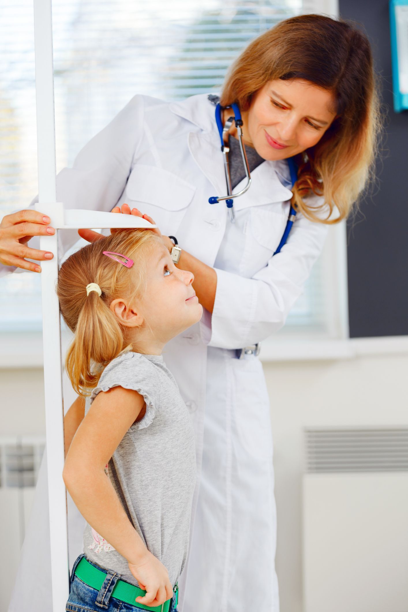 Little girl being measured for height at a pediatrician's office