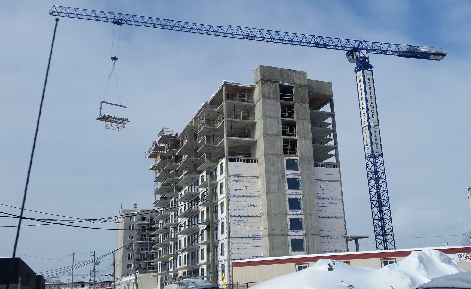 Un bâtiment en construction avec une remontée mécanique en arrière-plan