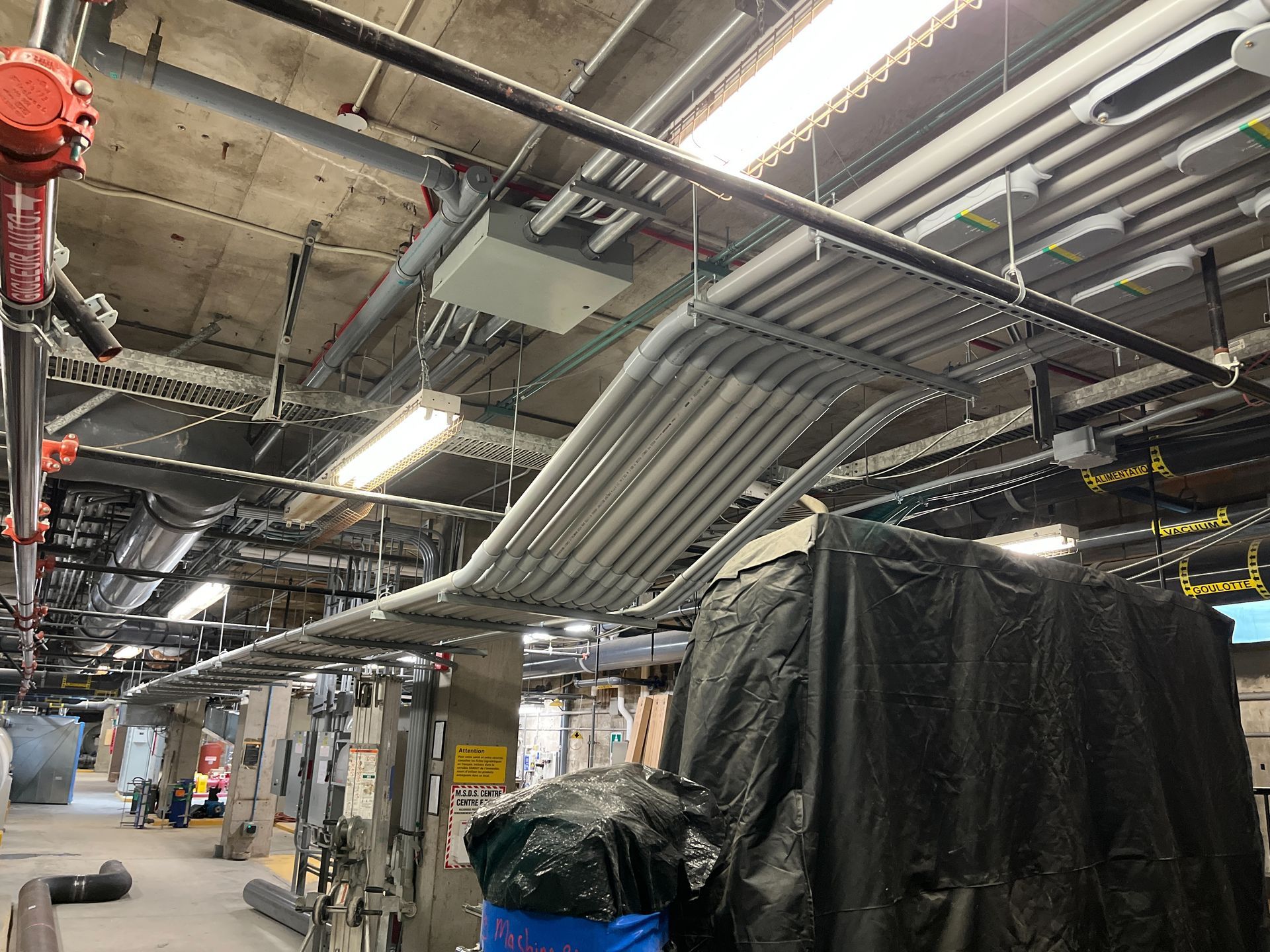 Un tas de tuyaux pendent du plafond d'un bâtiment.