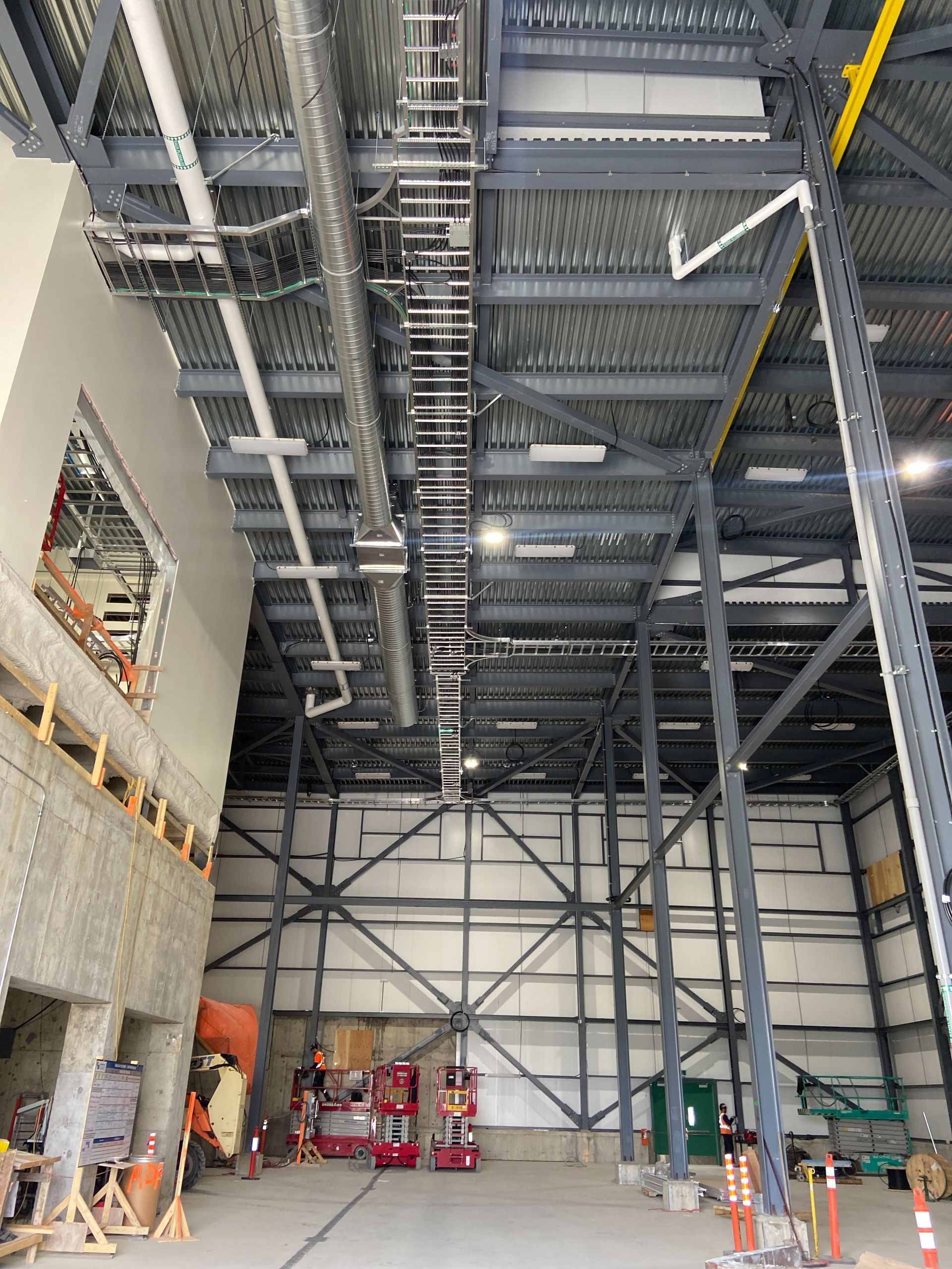 Un grand entrepôt avec beaucoup de tuyaux suspendus au plafond.