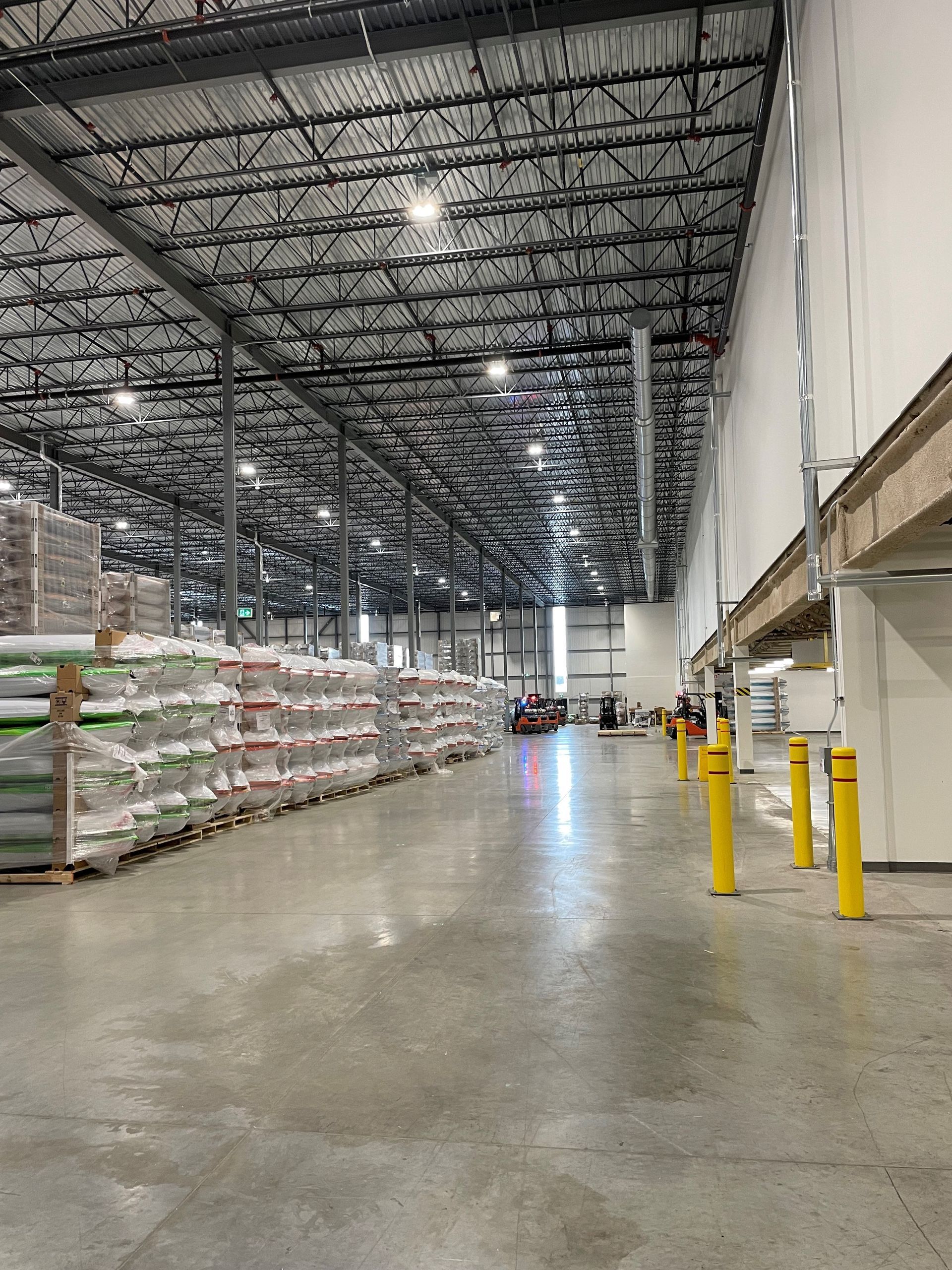 Un grand entrepôt rempli de nombreux sacs et poteaux.