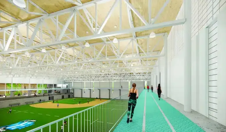 Une femme court sur une piste dans une salle de sport.