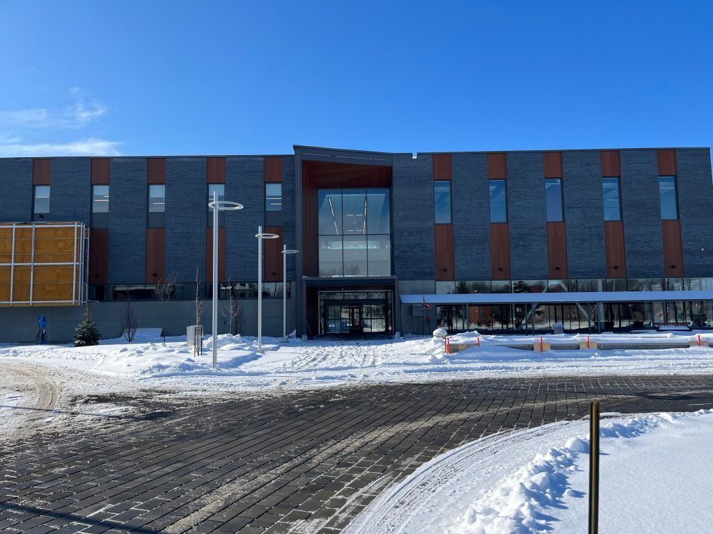 Un grand bâtiment avec de la neige sur le sol devant lui