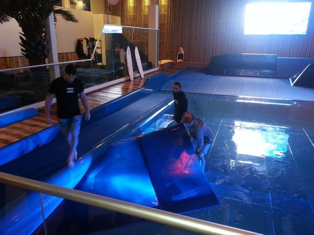 Un groupe de personnes se tient dans une piscine avec des lumières bleues dessus