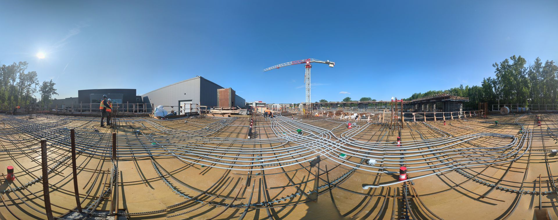 Une vue panoramique d'un chantier de construction avec une grue en arrière-plan.