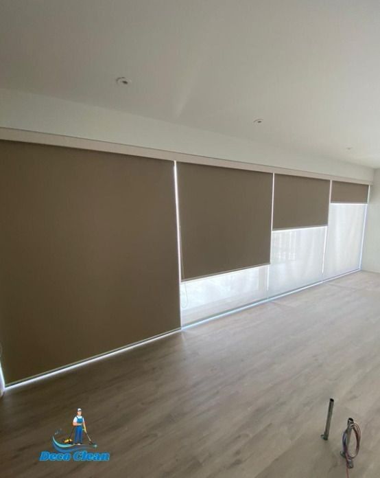 Una sala de estar con persianas en las ventanas y suelo de madera.