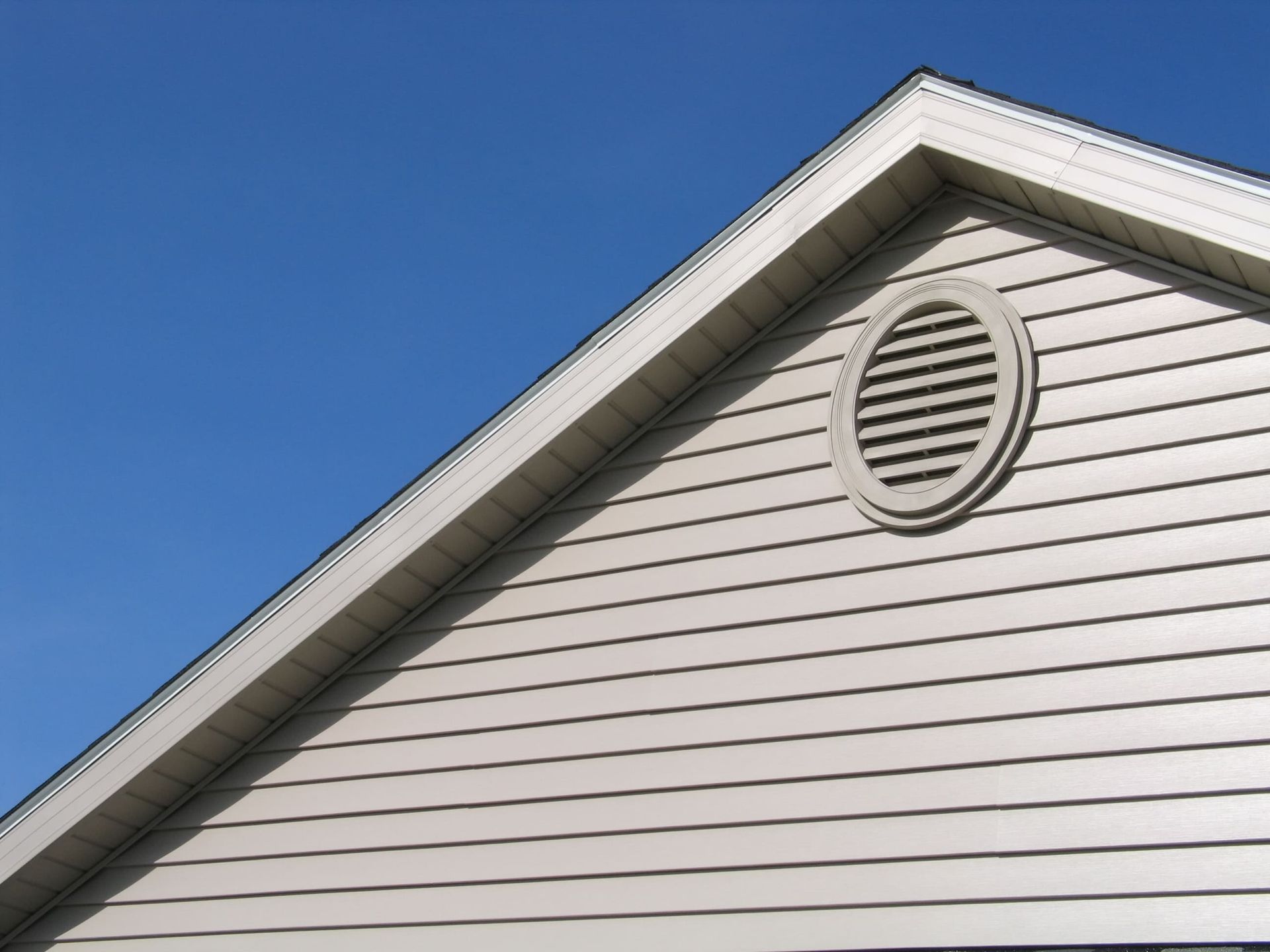 The roof of a house with a round vent on it