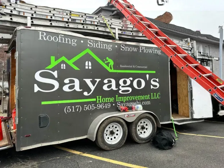 Sayago’s Home Improvement trailer with ladder and red roof rack at a work site