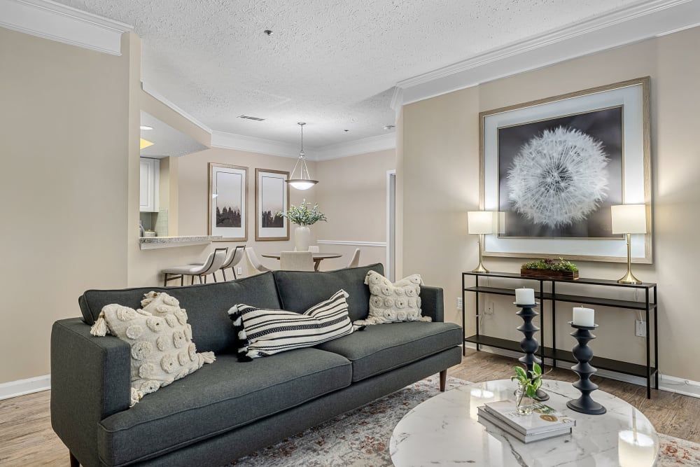 Modern living room with a couch, coffee table, and a painting on the wall at Marquis at Sugarloaf in Duluth, GA.