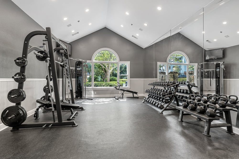 Apartment gym filled with lots of dumbbells and exercise equipment at Marquis at Sugarloaf in Duluth, GA.