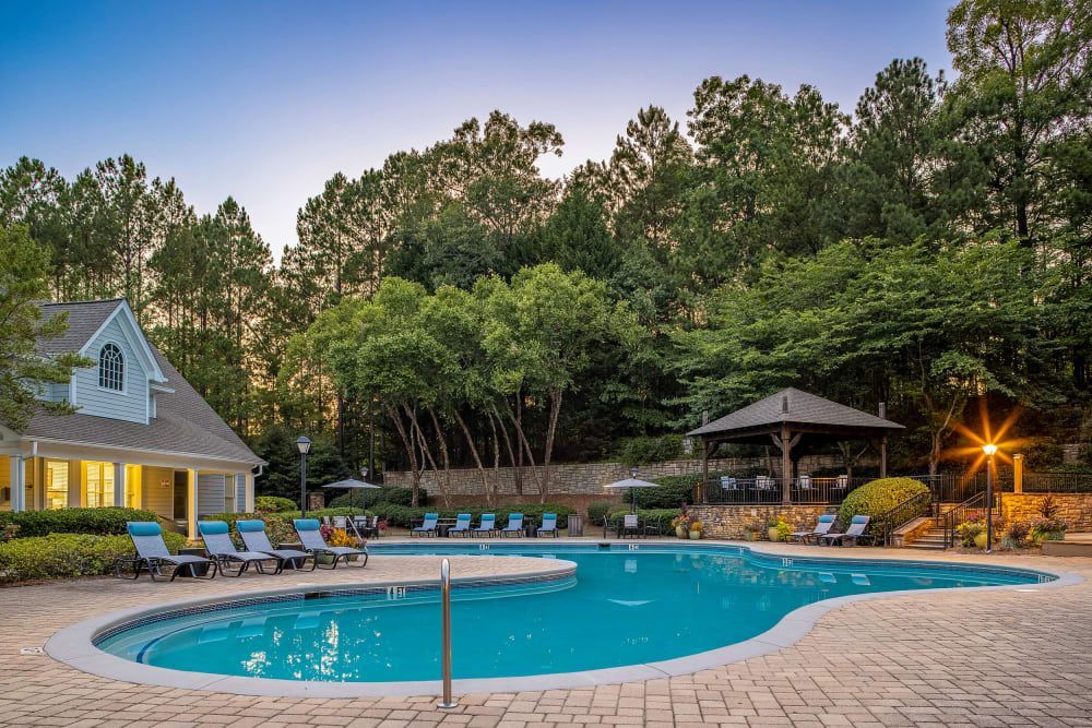 A large swimming pool surrounded by trees at Marquis at Sugarloaf in Duluth, GA.