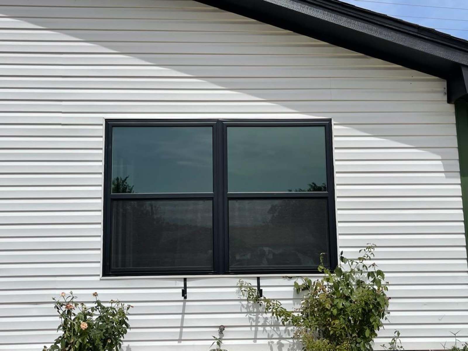 Black framed window on white siding.
