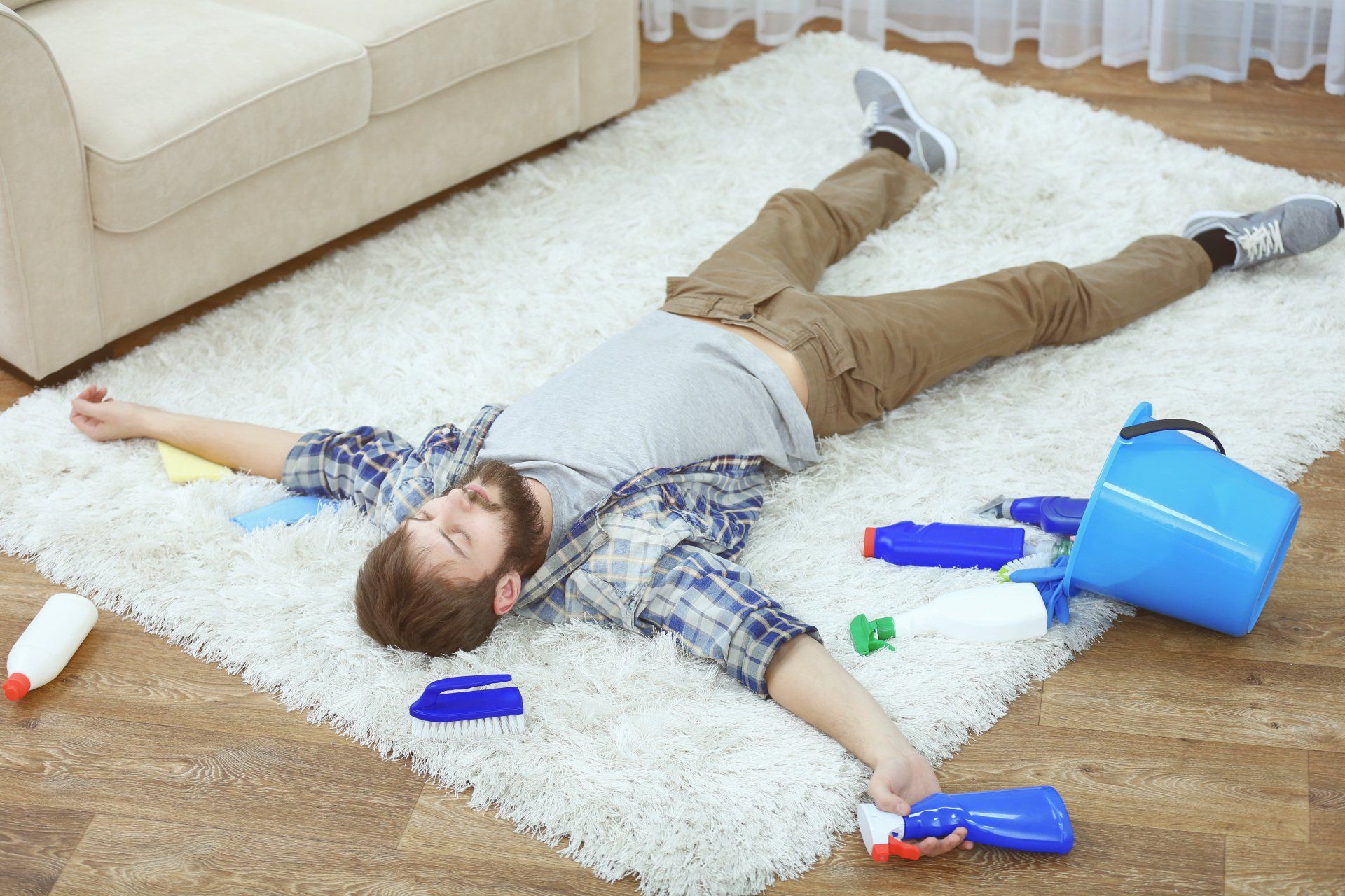 Funny young man tired of cleaning carpet at home