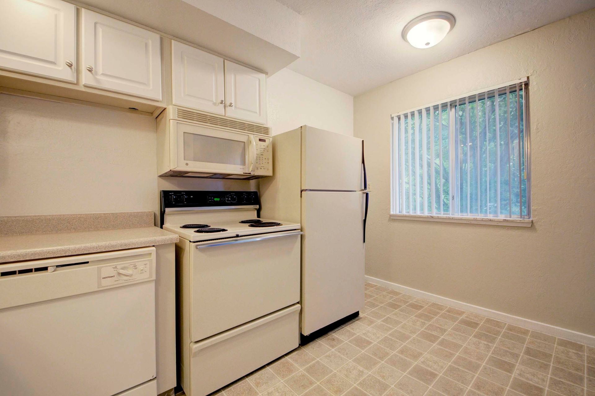 a kitchen with a stove , refrigerator , dishwasher and microwave at Camelot Place.