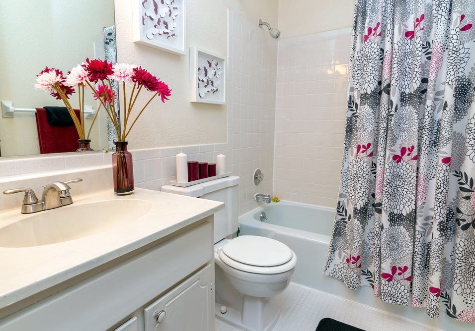 a bathroom with a toilet , sink , bathtub and shower curtain at Camelot Place.